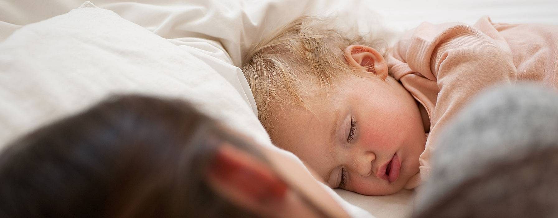 Bambino piccolo e biondo dorme nel letto