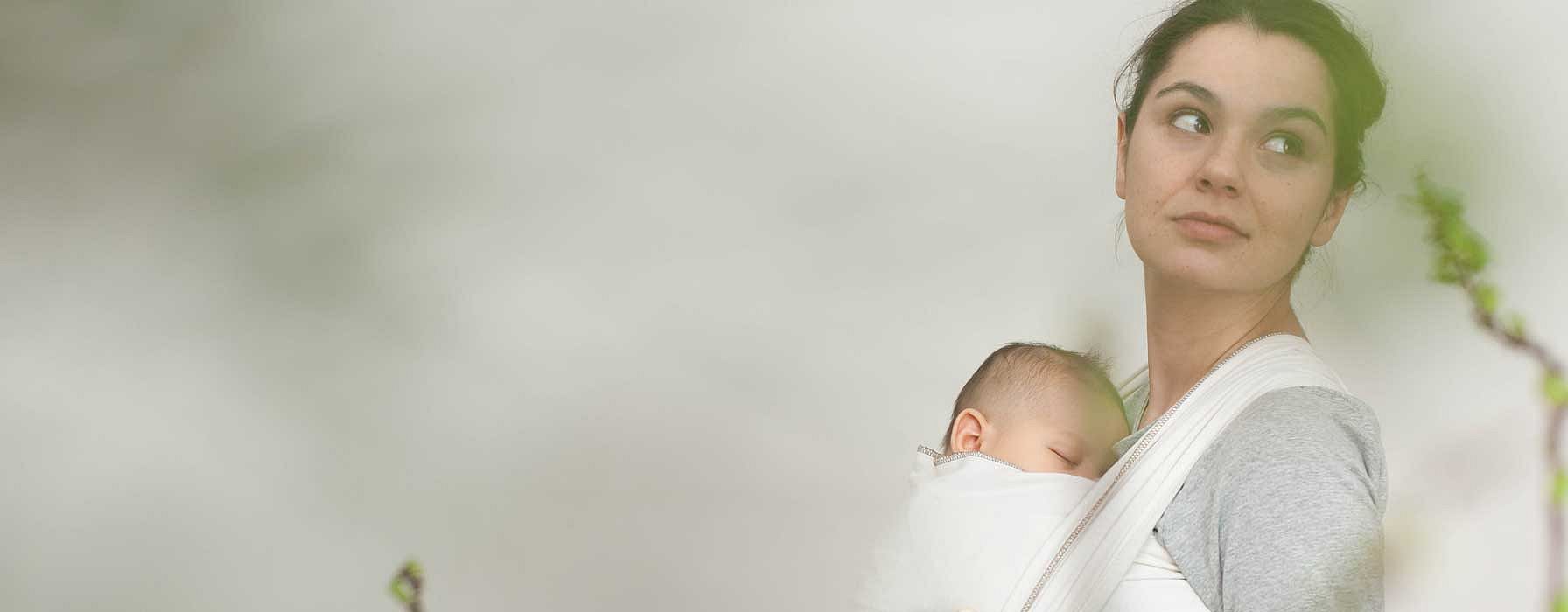 Mamma tiene in braccio un neonato mentre lui dorme