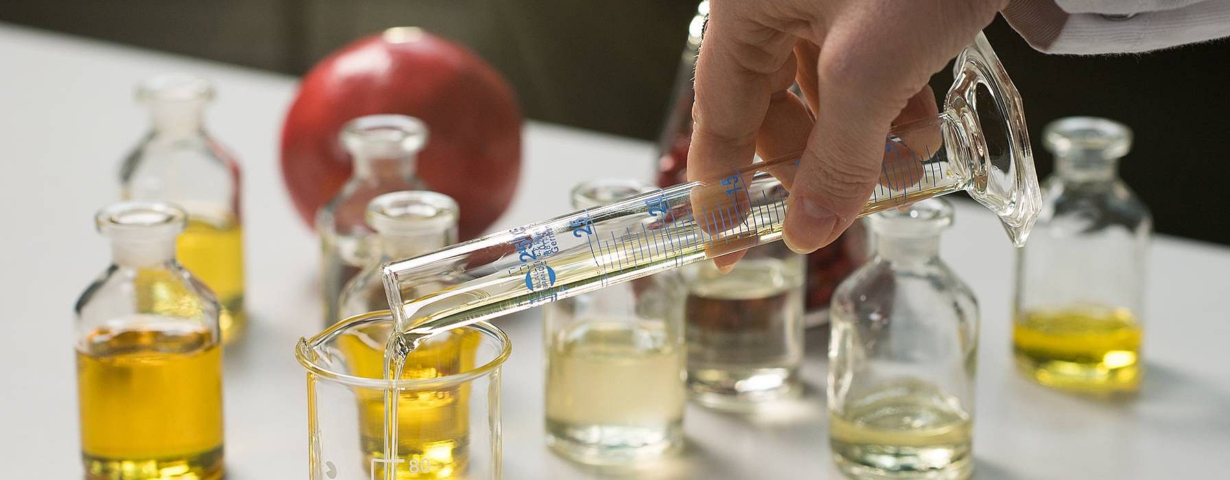 Set di oli naturali e mano che crea una miscela tra questi