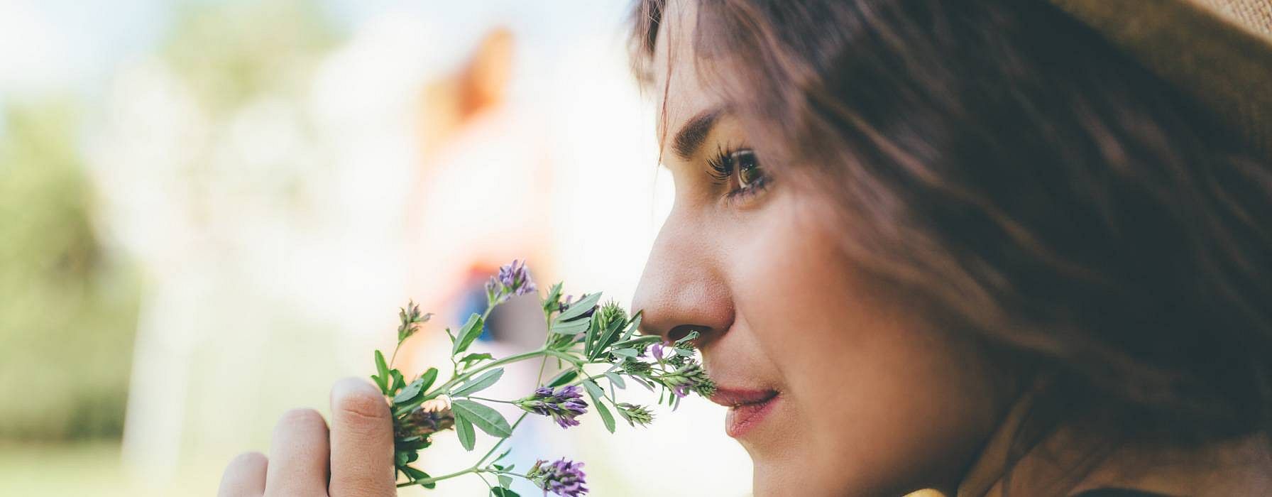 Ragazza annusa fiorellini lilla