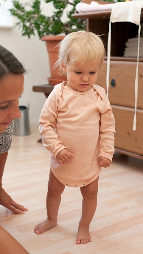 Bimbo scalzo in piedi vicino la mamma