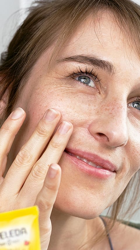 Donna applica crema su viso
