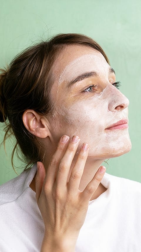 Donna ha uno strato di crema su tutto il viso