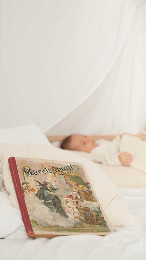 Libro di storie in primo piano, neonato che dorme in secondo piano