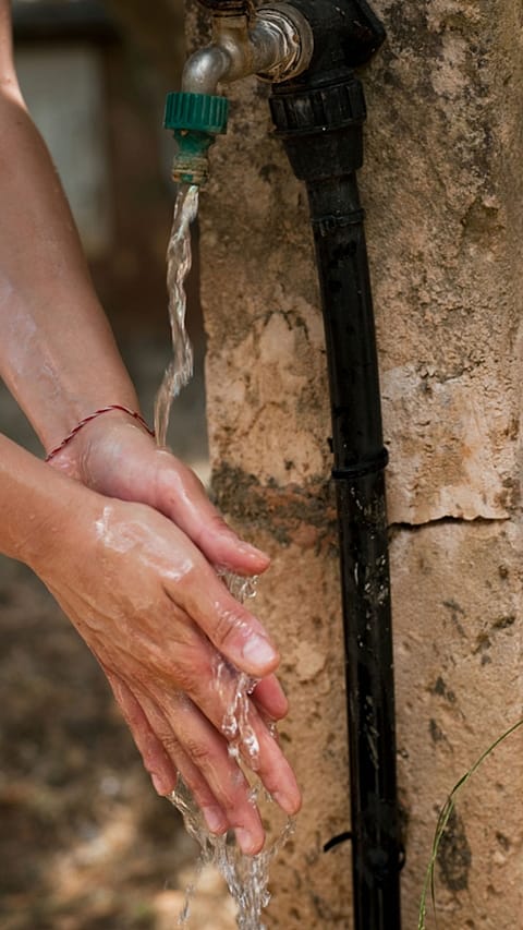 dettaglio di mani sciacquate sotto un getto d'acqua