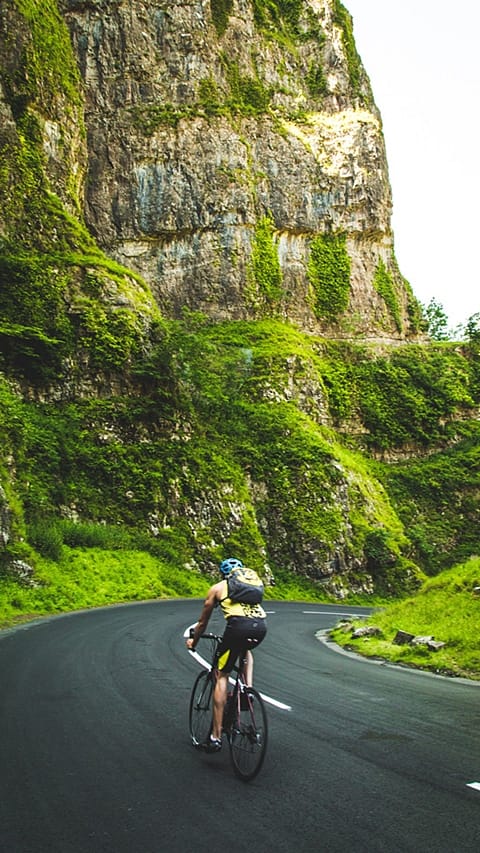 Uomo mentre va in bicicletta in montagna