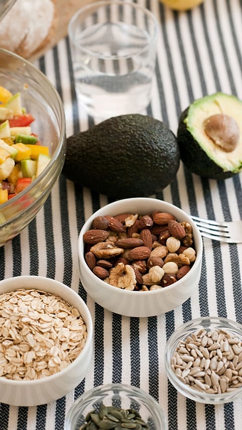 dettaglio di una tavola: frutta secca e avocado