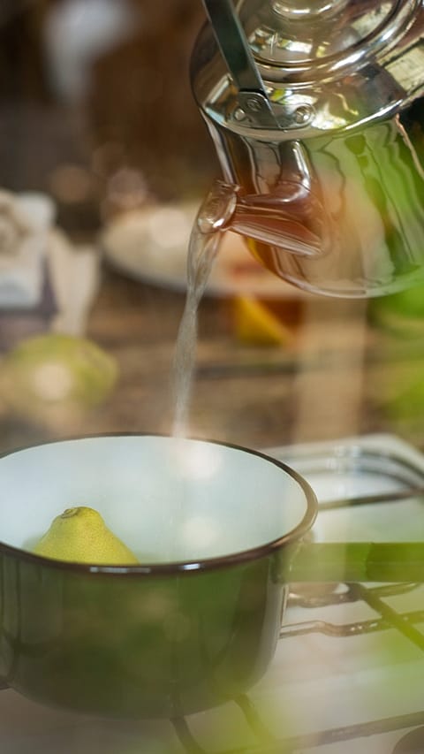 acqua calda versata in una tazza con limone