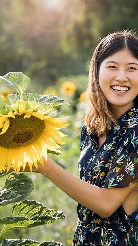 Ragazza sorride vicino ad un girasole