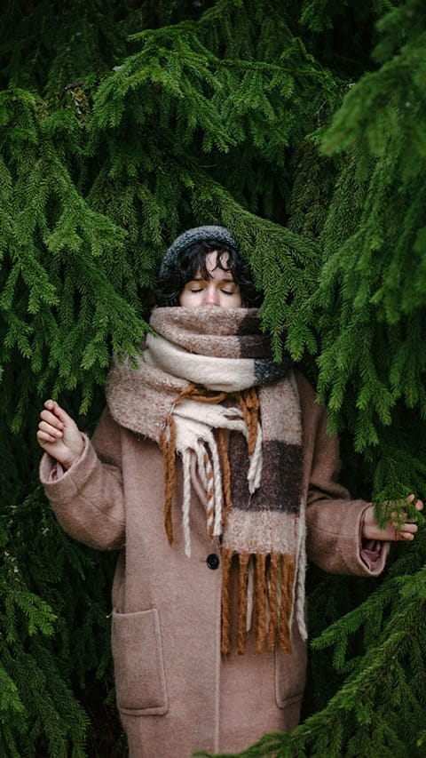 La donna sta sotto l'albero di Natale