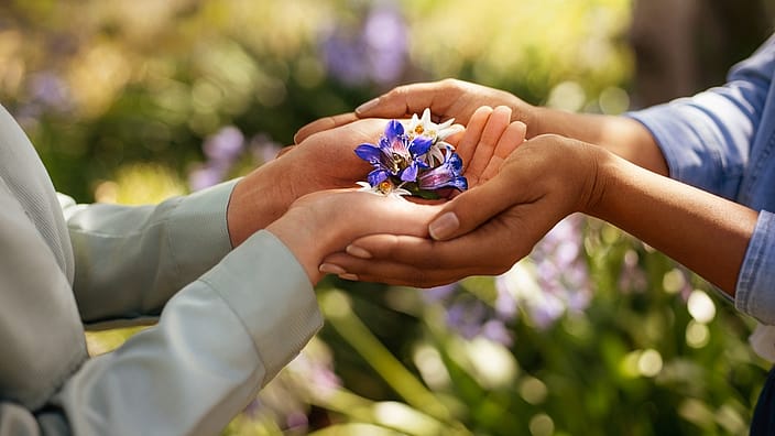Mani che tengono insieme i fiori