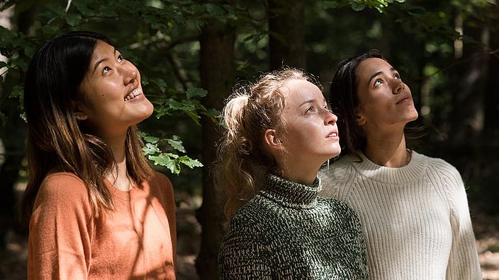 Tre donne sorridenti nella foresta