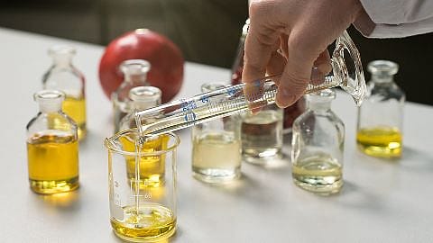Set di oli naturali e mano che crea una miscela tra questi