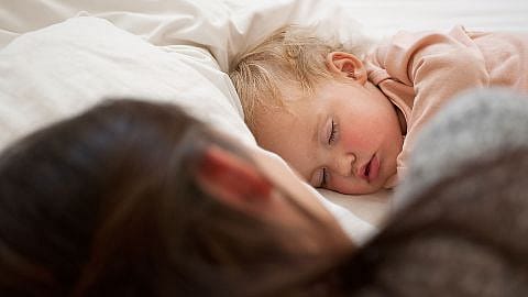 Bambino piccolo e biondo dorme nel letto
