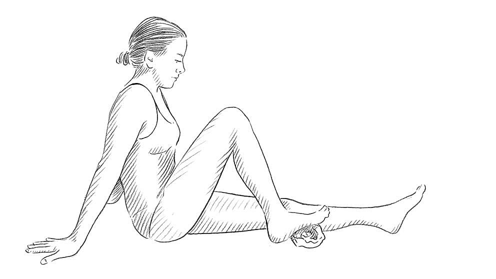 Disegno di donna che poggia il piede su un asciugamano arrotolato mentre è seduta a terra