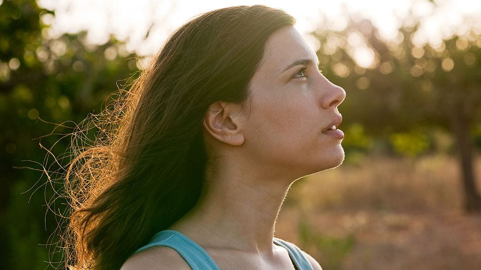 Donna ha il vento tra i capelli mentre è all'aperto