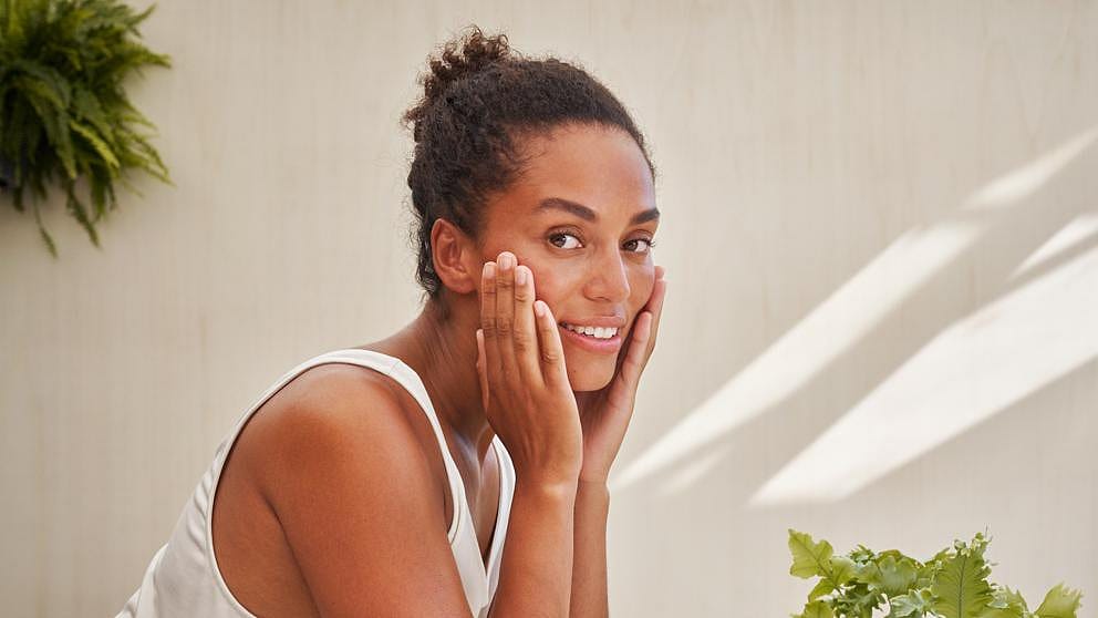 woman applying balm to face