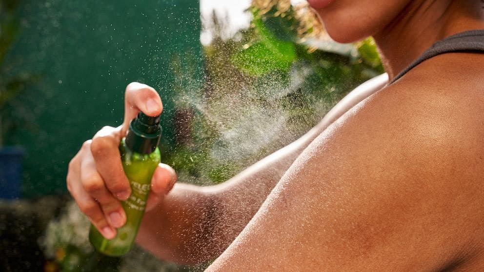 donna che applica l'olio spray